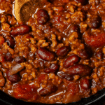 Bol de Chili con carne mexicain garni de crème fraîche, fromage râpé et coriandre fraîche.