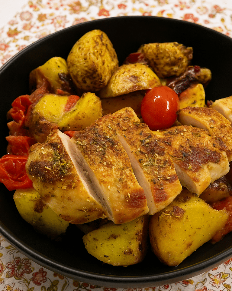 Pommes de terre, oignon rouge et poulet cru enrobés de pesto vert, d'origan et de paprika.