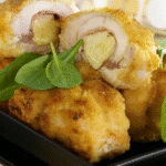 Escalopes de poulet aplaties, farcies d'une tranche de jambon et d'un bâtonnet de mozzarella, prêtes à être roulées.