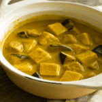 Bol de curry vert de dinde et aubergines crémeux, servi avec du riz et garni de coriandre.