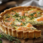 Quiche aux poireaux et saumon fumé sortie du four, avec une croûte dorée et croustillante. Quiche aux poireaux et au saumon fumé